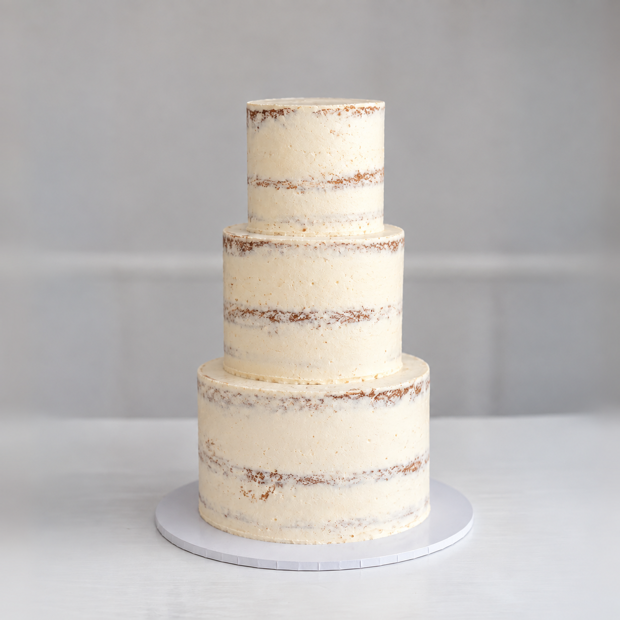 Owner cake reference showing semi-naked buttercream and exposed sponge bands